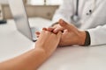 Man and woman doctor and patient having medical consultation with hands together at clinic Royalty Free Stock Photo