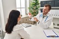 Man and woman doctor and patient having medical consultation holding urine analysis bottle at clinic Royalty Free Stock Photo