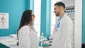 Man and woman doctors standing together speaking at the clinic