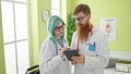 Man and woman doctors using touchpad working at clinic