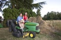 Man, Woman, and Dog on a Tractor - Horizontal Royalty Free Stock Photo