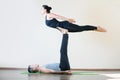 Man and woman doing acro yoga or pair yoga indoor