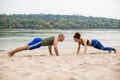 Man and woman doing push-ups on sand Royalty Free Stock Photo