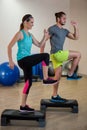 Man and woman doing step aerobic exercise on stepper Royalty Free Stock Photo
