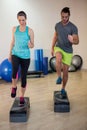 Man and woman doing step aerobic exercise on stepper Royalty Free Stock Photo