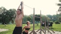 Man and woman doing various bodyweight exercises at the horizontal bar