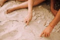 Man and woman draw their hands on the heart in the sand Royalty Free Stock Photo