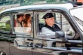 Man and woman driving in vintage taxi