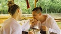 Man and woman eat and drink tasty beverages spending time in traditional local floating cafe on water. Loving happy