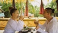 Man and woman eat and drink tasty beverages spending time in traditional local floating cafe on water. Loving happy