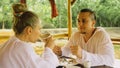 Man and woman eat and drink tasty beverages spending time in traditional local floating cafe on water. Loving happy