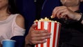 Man and woman eating popcorn at the cinema