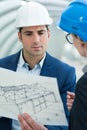 man and woman examining technical drawing Royalty Free Stock Photo