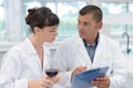 Man and woman experts in white coats checking wine quality Royalty Free Stock Photo