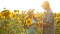 Man and woman farmers with a tablet work in the field with sunflowers. The concept of agriculture. agriculturist and