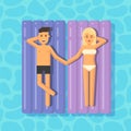 Man and woman floating on mattresses in a swimming pool holding