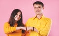 Man and woman friends isolated on pink studio background give fists bump look at camera