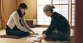 Man, woman and game with Japanese cards on floor in challenge, contest or problem solving with clue. People, couple and