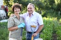 Man and woman gardeners with shovel and bucket while gardening