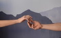 Man and woman giving each other hands on grey background. Concept of support and help Royalty Free Stock Photo