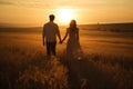 A man and a woman, hand in hand, walking through a beautiful field at sunset, embodying love and connection, Couple holding hands Royalty Free Stock Photo