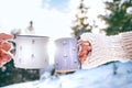 Man and woman hands in knitting mittens taking cups of hot drink Royalty Free Stock Photo