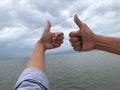 Man and woman hands showing thumbs up on blue sky background Royalty Free Stock Photo