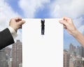 Man and woman hands tearing blank paper with businessman hanging