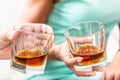 Man and woman hands toasting with glasses of whiskey brandy or rum indoors - closeup Royalty Free Stock Photo