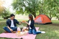 Man and woman happy drink in front of camping tent