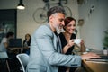 Man and woman having business meeting in a cafe, using laptop. Royalty Free Stock Photo