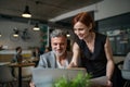 Man and woman having business meeting in a cafe, using laptop. Royalty Free Stock Photo