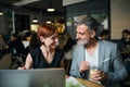 Man and woman having business meeting in a cafe, using laptop. Royalty Free Stock Photo