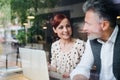 Man and woman having business meeting in a cafe, using laptop. Royalty Free Stock Photo