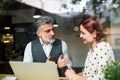 Man and woman having business meeting in a cafe, using laptop. Royalty Free Stock Photo