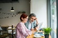 Man and woman having business meeting in a cafe, using laptop. Royalty Free Stock Photo