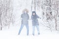 Love, relationship, season and friendship concept - man and woman having fun and playing with snow in winter forest Royalty Free Stock Photo