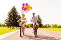 Man and woman having fun on summer day and cycling with balloons Royalty Free Stock Photo