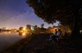 Man and woman having a rest on shore under night sky Royalty Free Stock Photo