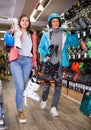 man and woman in helmets choosing sports equipment