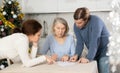 Married couple helps elderly mother write testament in kitchen at christmas Royalty Free Stock Photo