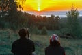 Man and woman hikers sit on the mountainside in sun loungers