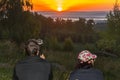 Man and woman hikers sit on the mountainside in sun loungers