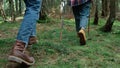 Man and woman in hiking boots walking in woods. Hikers trekking in forest