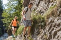 Man and woman hiking on the steep path above the mountain river