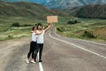 A man and a woman are hitchhiking. Wanderlust, autostop journey concept. Young people traveling hitchhiking. Tourists