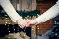 A man and a woman hold hands close-up on the background of blurry lights Royalty Free Stock Photo