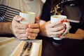 Man and woman hold a mug of coffee in cafe Royalty Free Stock Photo