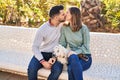 Man and woman holding dog hugging each other kissing at park Royalty Free Stock Photo