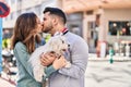 Man and woman holding dog standing together kissing at street Royalty Free Stock Photo